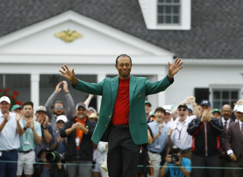 Tiger Woods smiles as he wears his green jacket after winning the Masters golf tournament