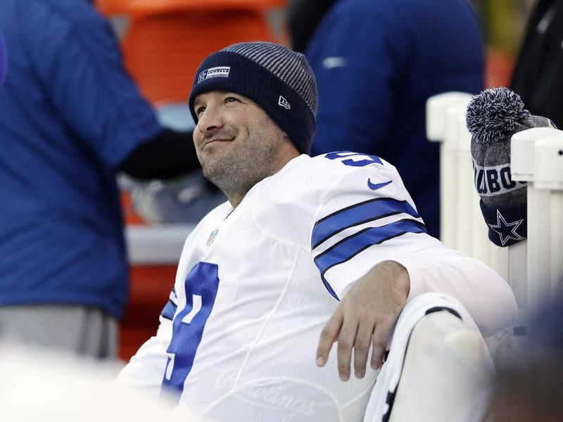 Tony Romo of Dallas Cowboys smiles on bench