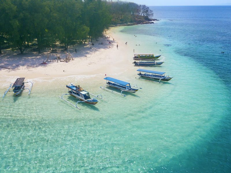 Tourist ships anchored on the Gili Rengit Beach in Lombok, Indonesia