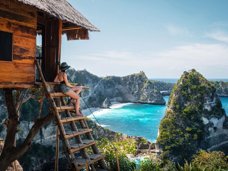 Traveler sitting on the stairs of a tree house in Bali