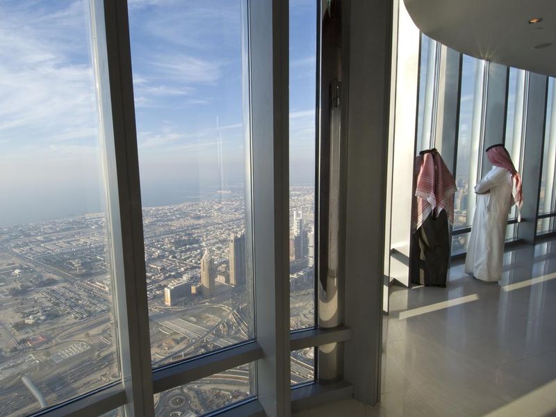 Two Arab men looking over Dubai from the Burj Khalifa