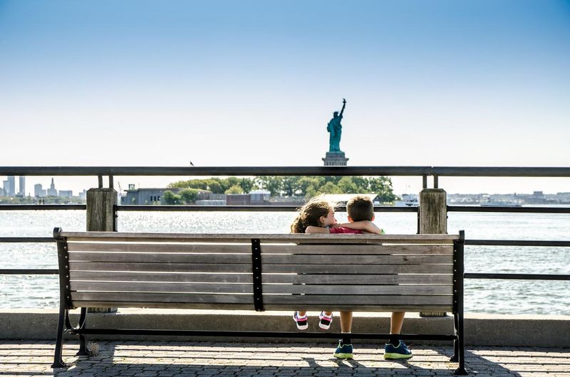 Two kids looking at Statue of Liberty