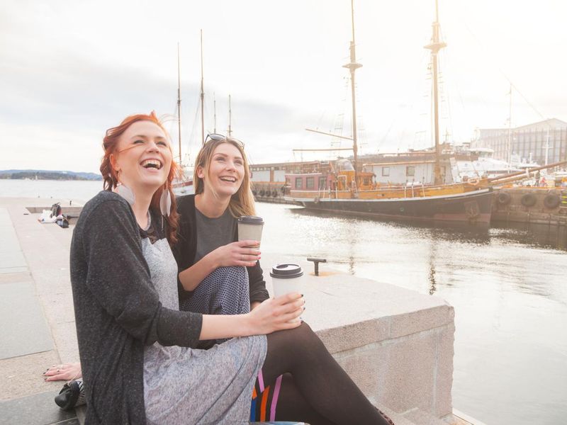 Two women drinking coffee on Oslo harbor