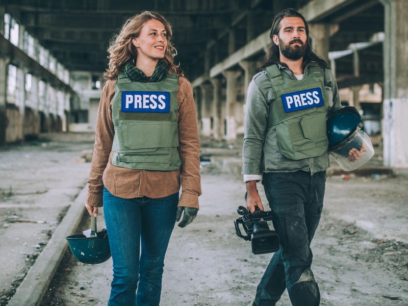 Two young journalists reporting in a war zone