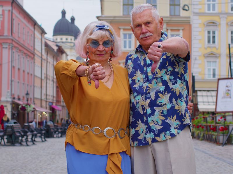 Unhappy man and woman travelers giving thumbs-down gesture
