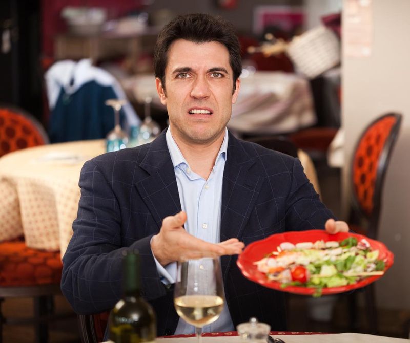Unhappy man holding a plate of food
