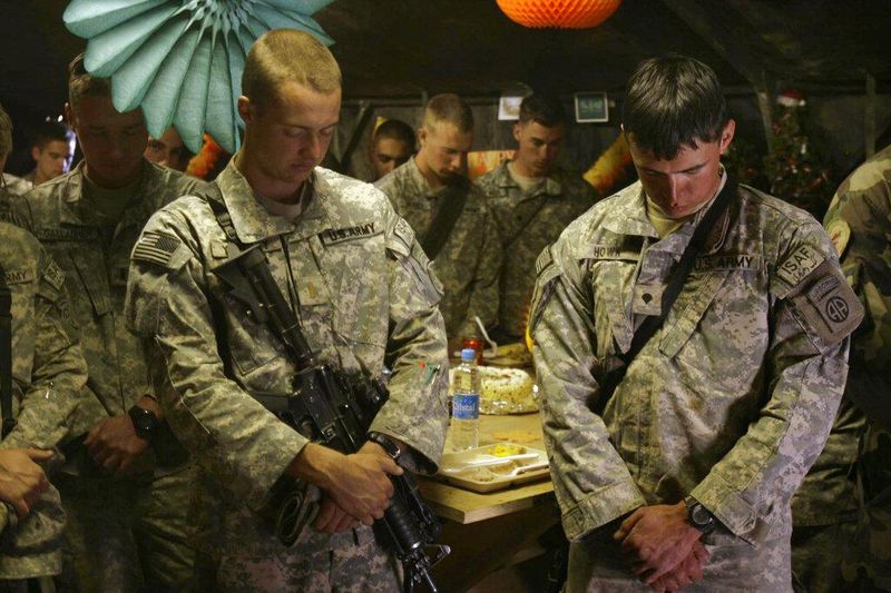 United States soldiers pray during a Thanksgiving Day celebration