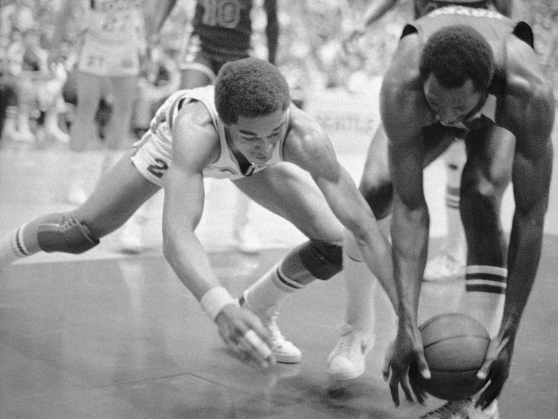Washington Bullets Elvin Hayes reaches in to grab loose ball from Seattle Supersonic Dennis Johnson