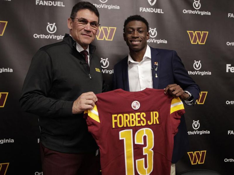 Washington Commanders head coach Ron Riviera, left, with first-round draft pick Mississippi State cornerback Emmanuel Forbes