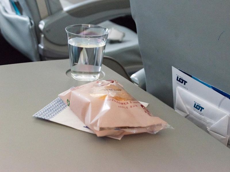 Water and apple bun on plane