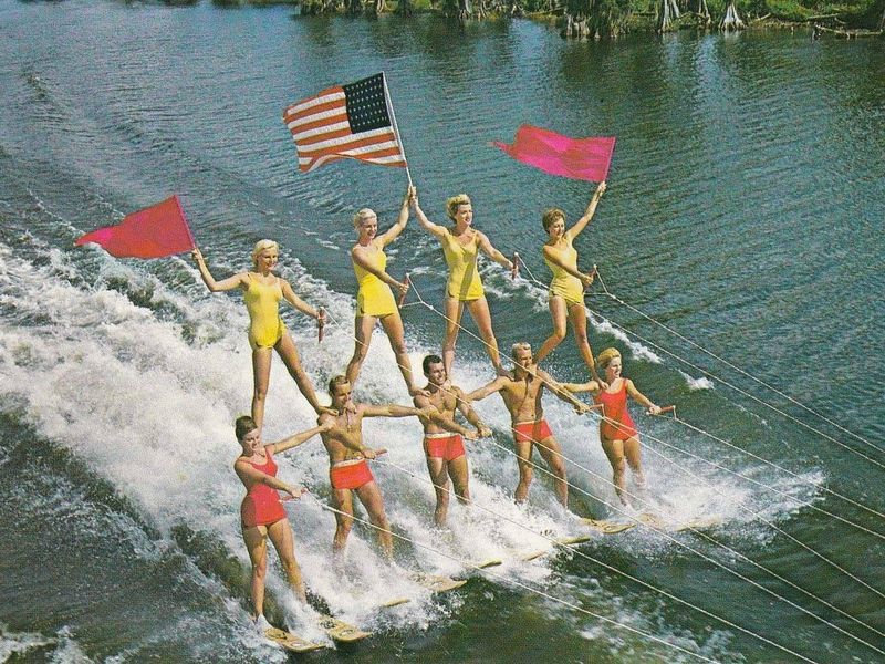 Water skiers holding flags