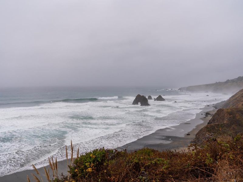 Waves coming to shoreline on foggy day