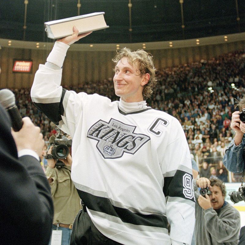 Wayne Gretzky waves a record book listing his career goals