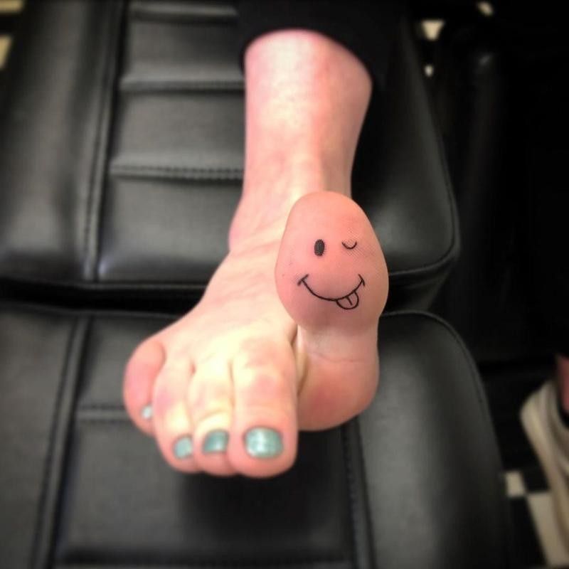 Winking Face on Bottom of Toe Tattoo Idea