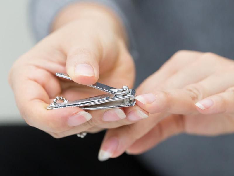 Woman cutting nails using nail clipper
