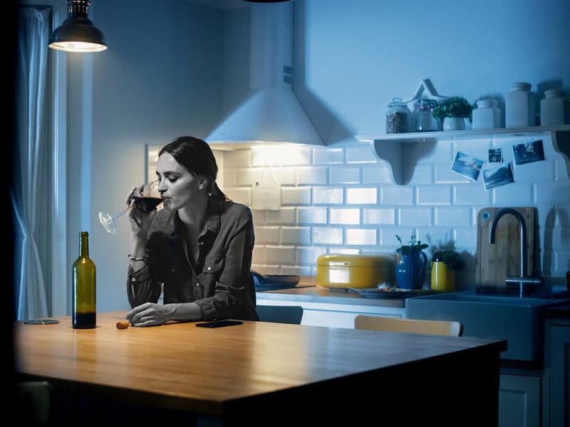 Woman drinking wine late at night