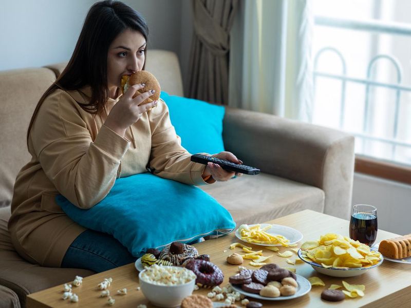 Woman eating on sofa