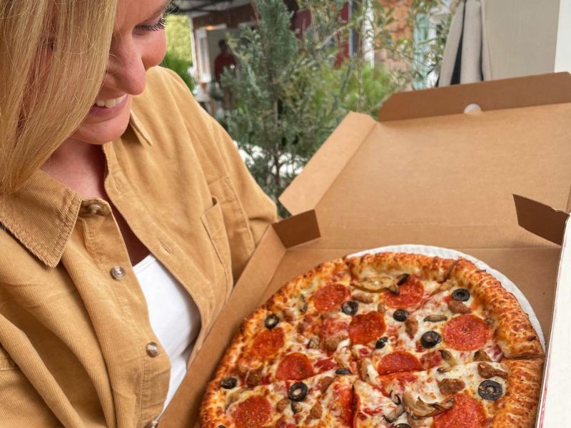 Woman holding a Hunt Brothers pizza box