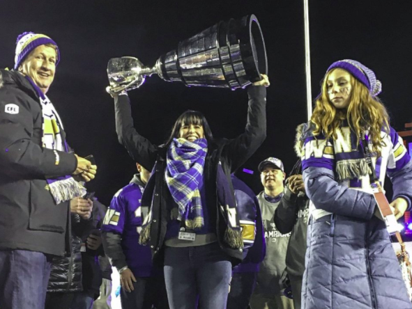 Woman holding up Grey Cup