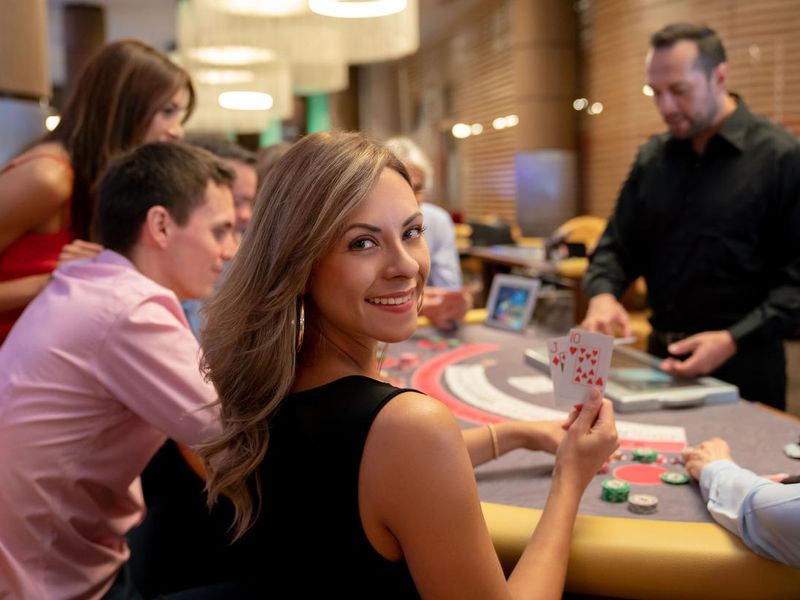 Woman holding winning cards at blackjack table in a casino