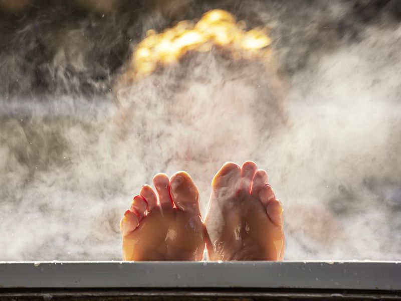 Woman holds her feet up while in a hot tub