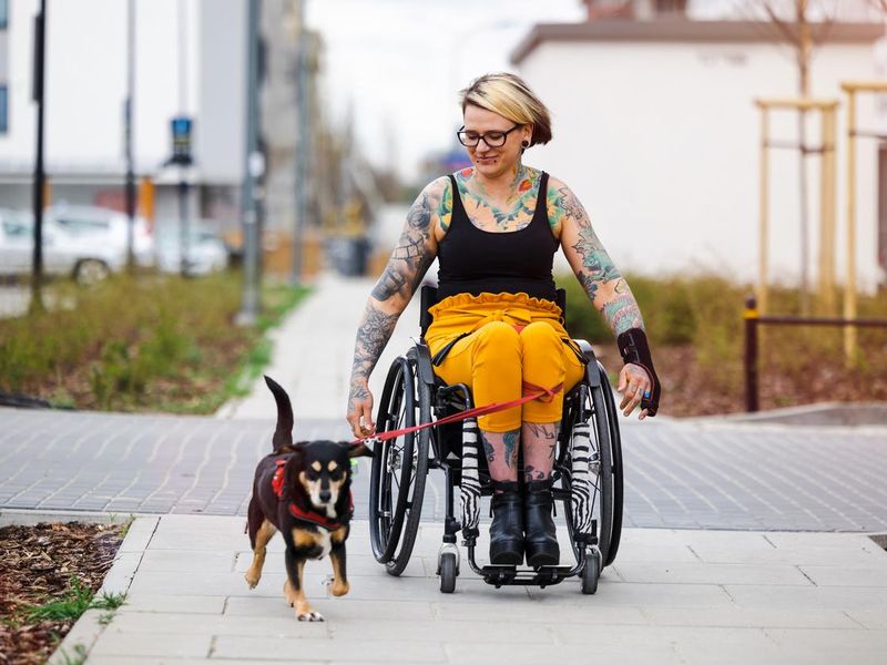 Woman in wheelchair with her dog outdoors
