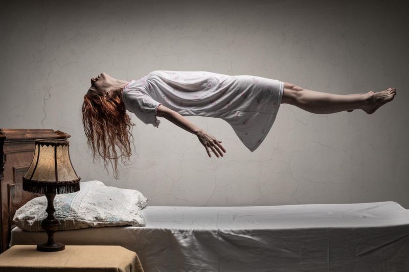 Woman levitating over bed