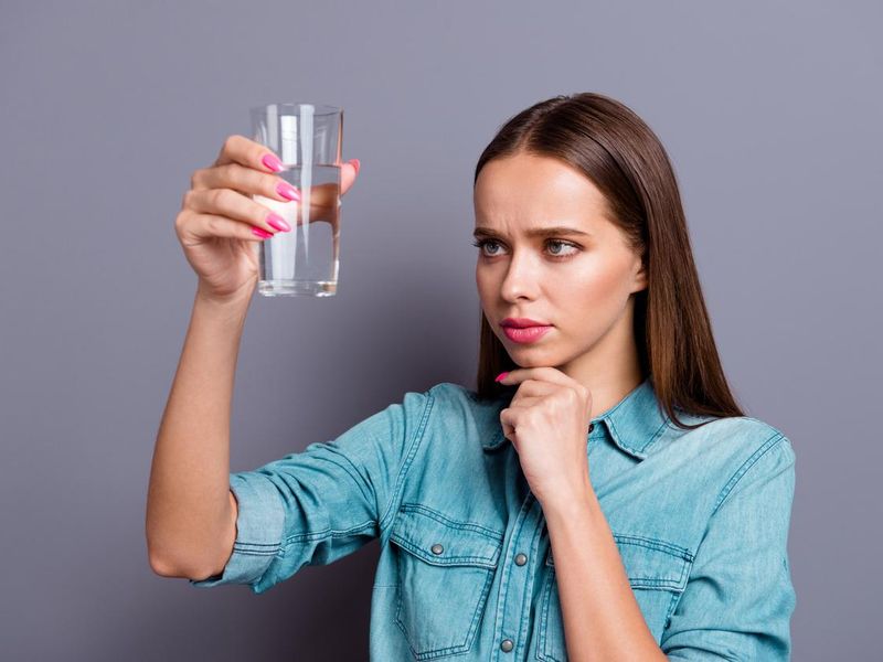 Woman looking at quality of water in glass