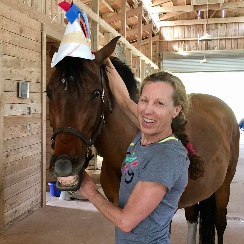 Woman posing with horse smiling for birthday