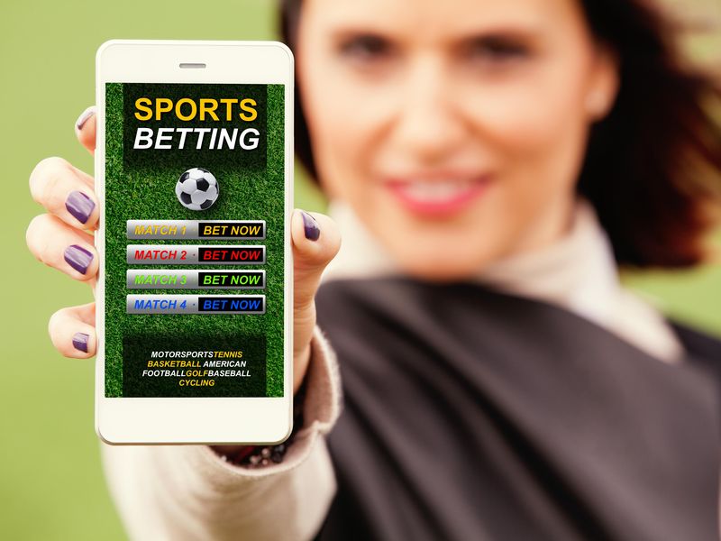 Woman showing mobile phone with sports betting website