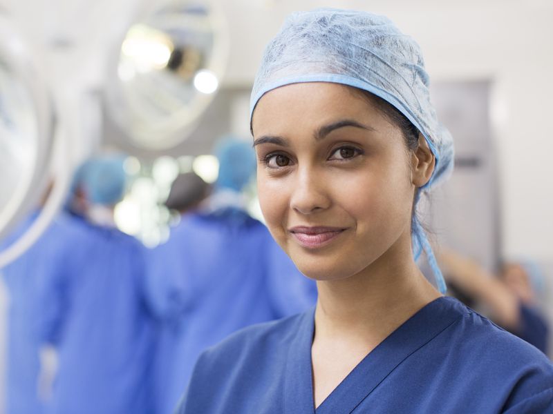 Woman surgical nurse wearing blue surgical cap and scrubs