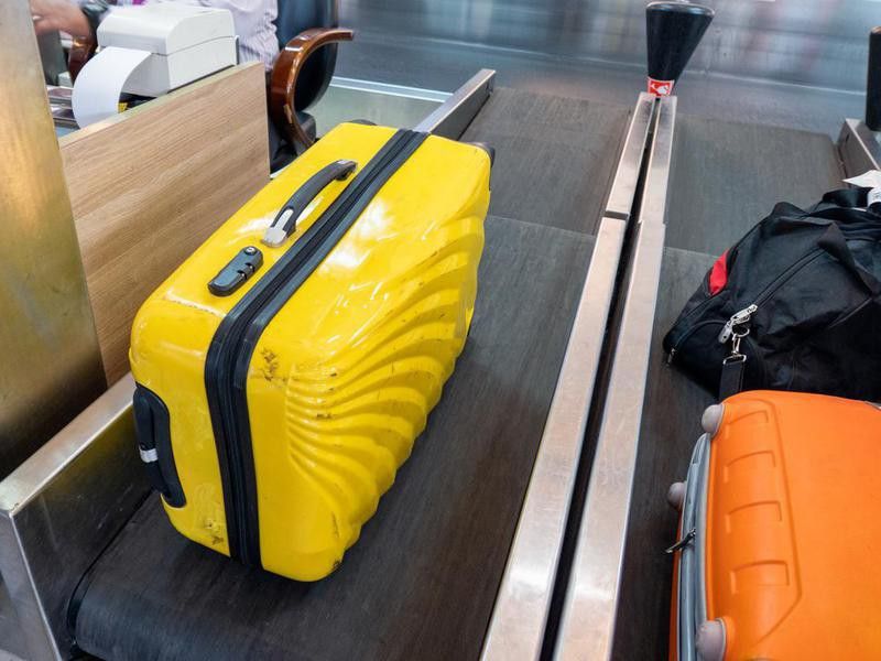 Yellow large luggage on belt at counter airline
