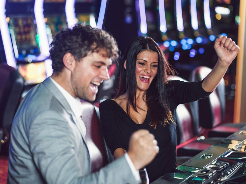 Young couple playing slot machines at a casino
