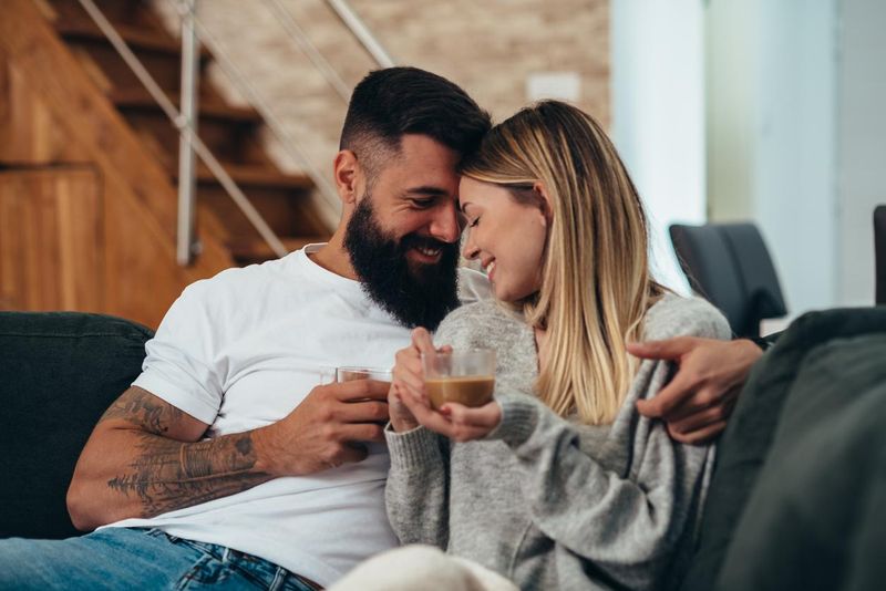 Young couple sharing a romantic morning moment while drinking coffee