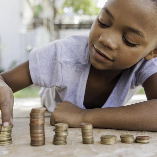 Young african female counting her coins while lying on the floor.
