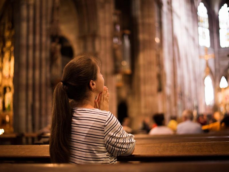 Young girl praying in church