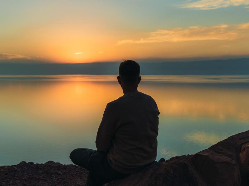 Young male contemplating the scenic sunset above the Dead Sea in Jordan