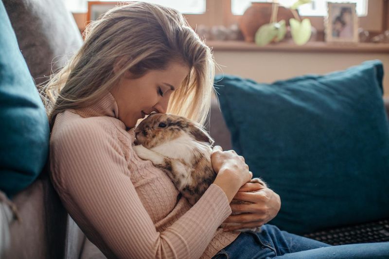 Young woman snuggling a pet rabbit