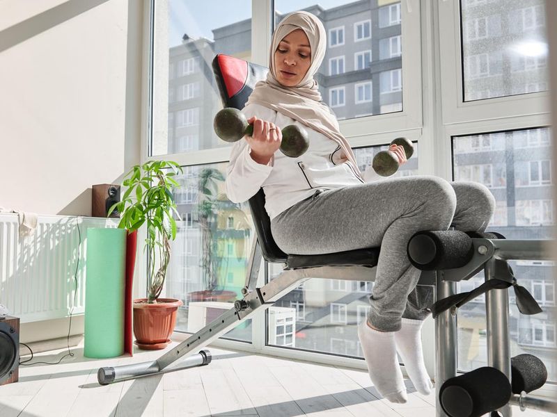 Young woman with weight bench set